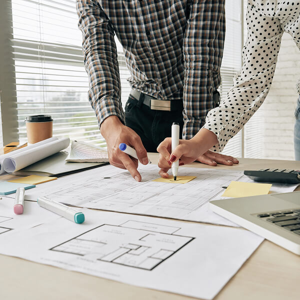 Duas pessoas fazendo marcações em uma folha